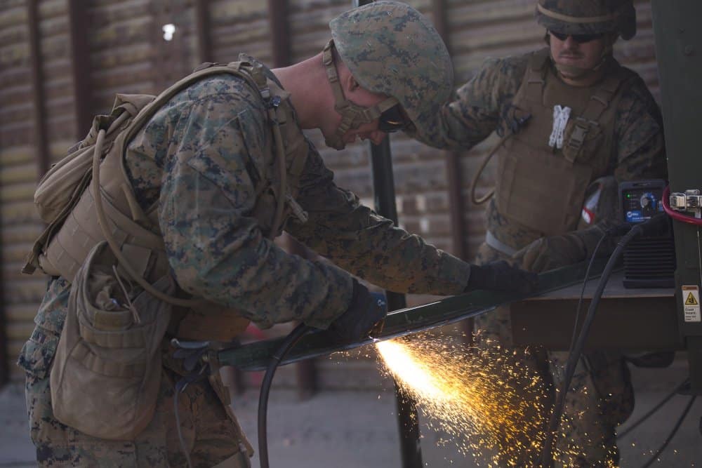 Welder in the army - grinding a pipe