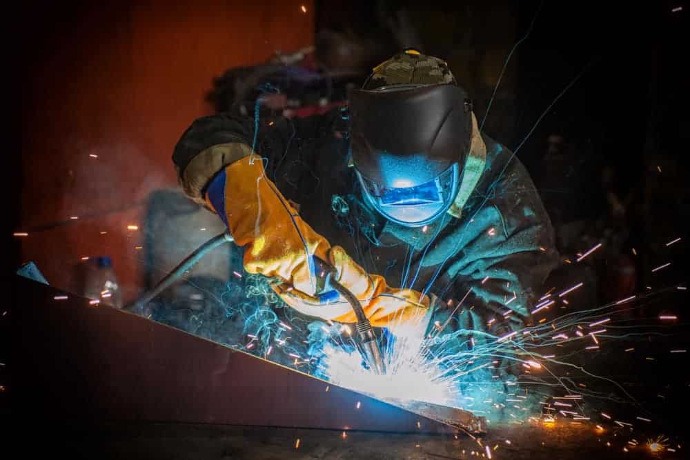 image of a worker welding metal with proper mig welding safety gear