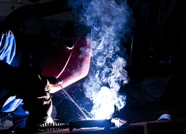 image of a worker laying a stick weld