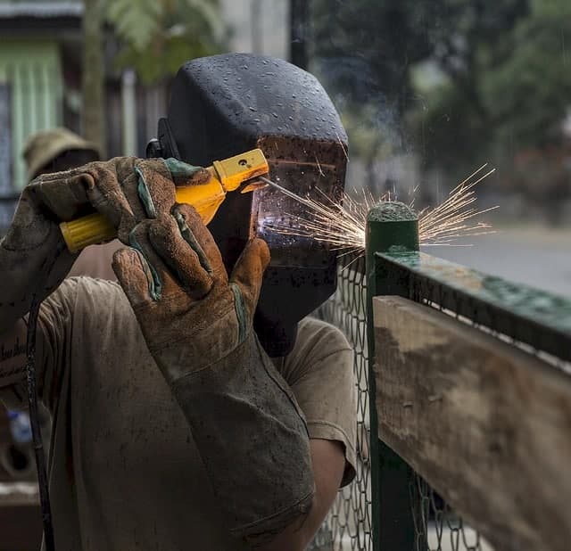 imagen de un soldador trabajando en una valla