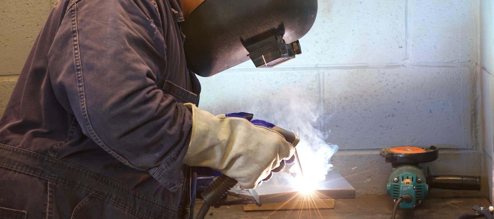 image of a worker welding in his garage