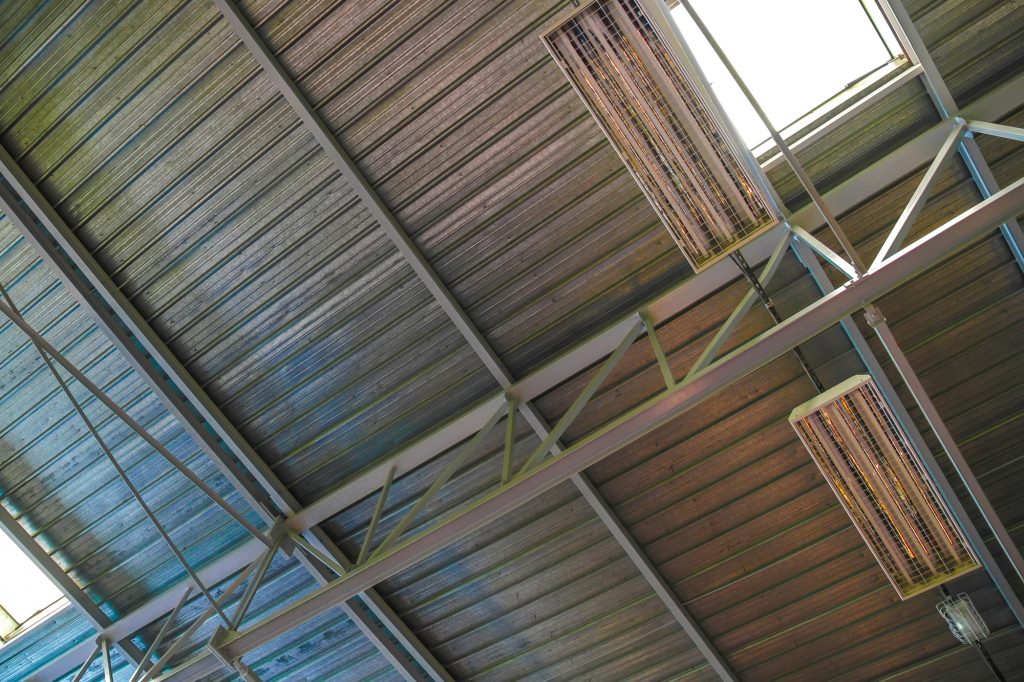 View on the ventilated ceiling of an industrial building with lamps.