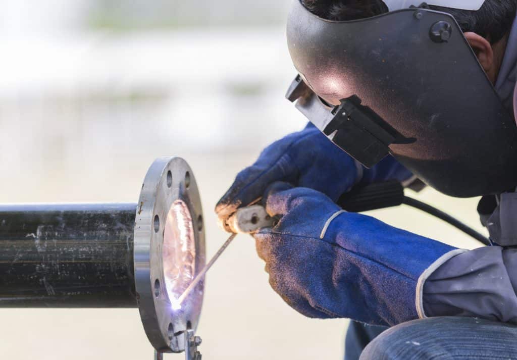image of a welding worker wearing safety gloves while working