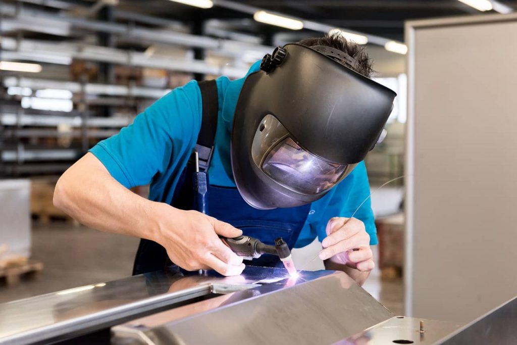 Worker using Oxyacetylene gas to weld in sheet metal factory