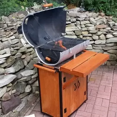 DIY BBQ Keg Pit with fire coming out of it 
