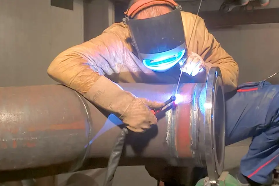image of a welder TIG welding a pipe