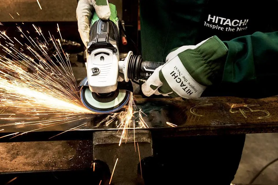 image of a worker grinding a flat steel bar