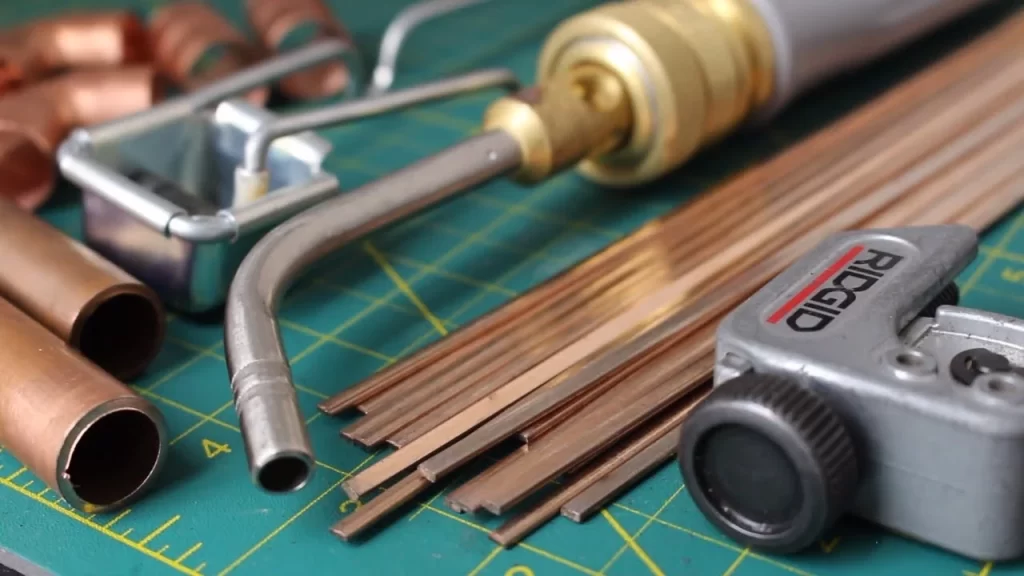 Image of tools used for cupper brazing. ( torch, brazing rods and copper pipes