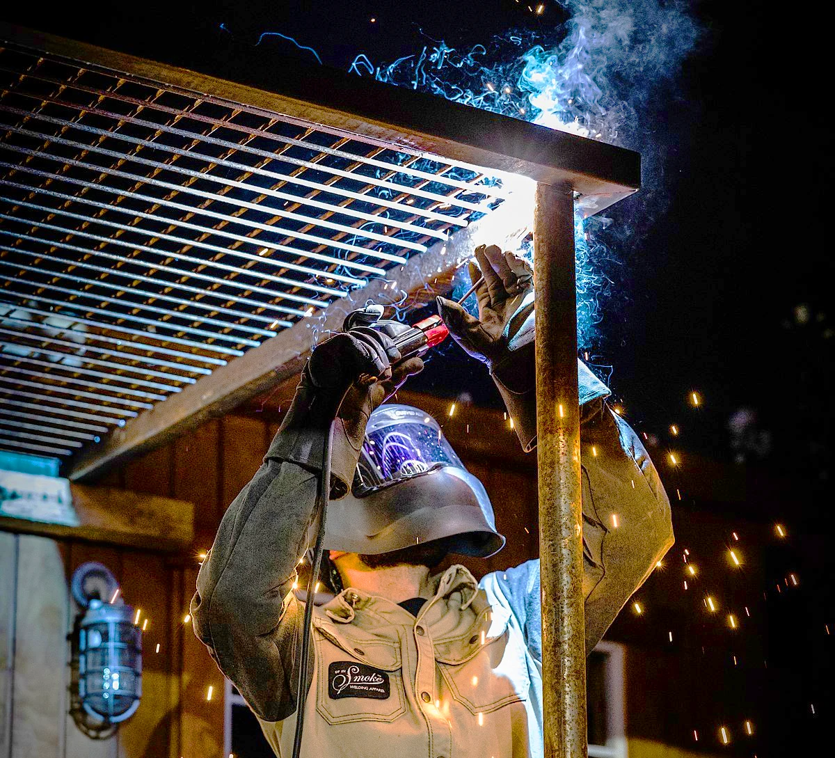 Image of a welder welding in overhead position with stick welder.