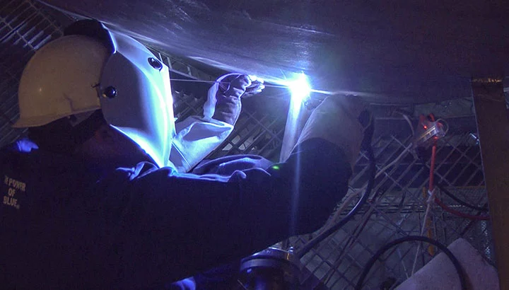 TIG welder working in uncomfortable position